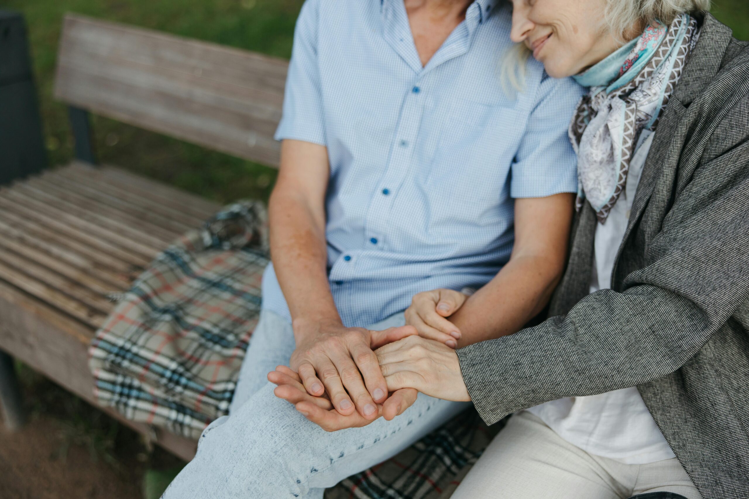 elderly sitting together holding hands