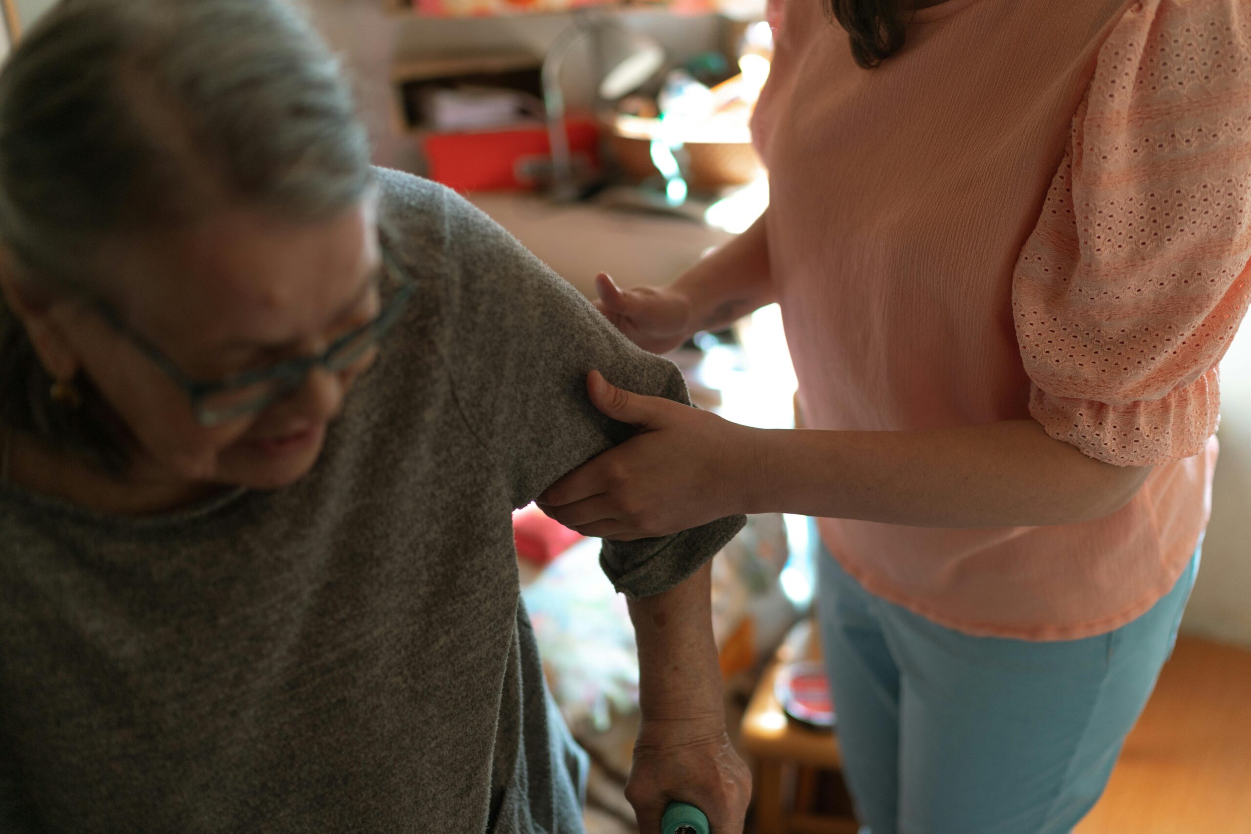 Woman helping elderly to stand